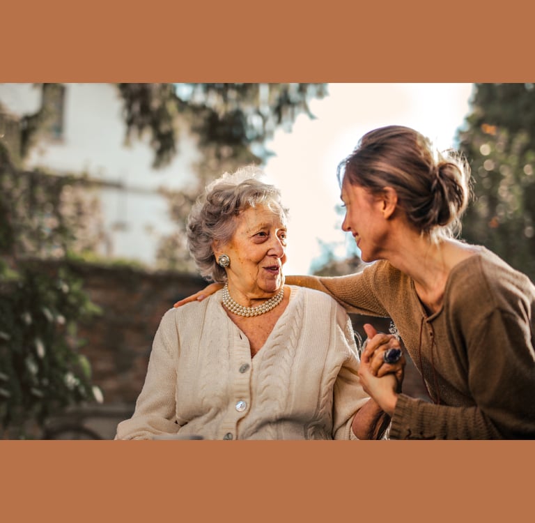 Older woman being comforted by a younger, middle-aged woman.