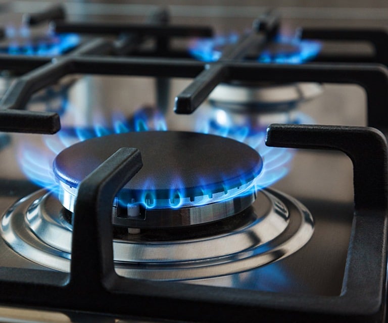 a gas stove top with blue flames on it