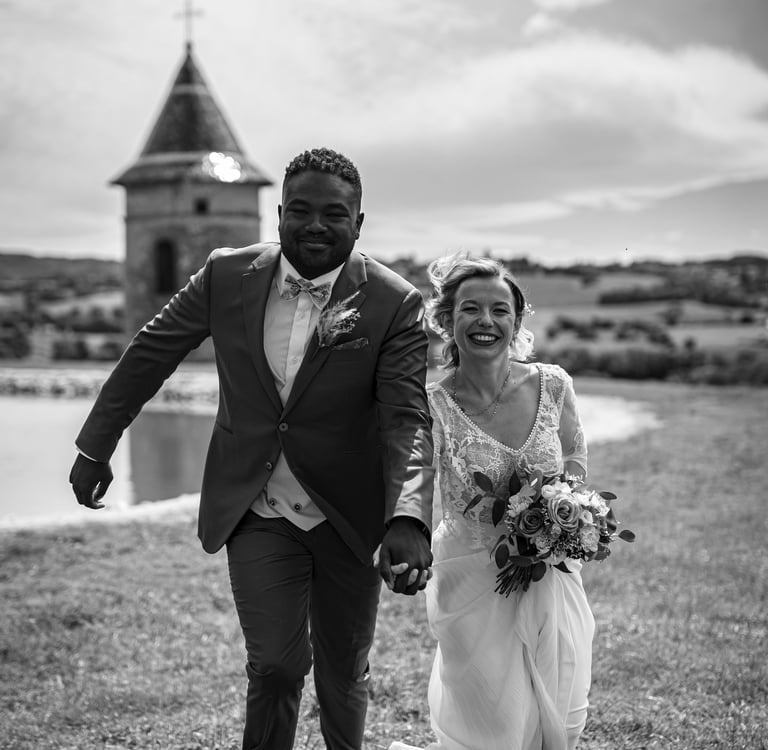 a bride and groom running on grass