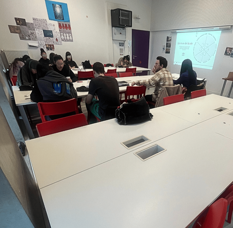 Students collaborate in a modern classroom setting with a projector screen showing a diagram.