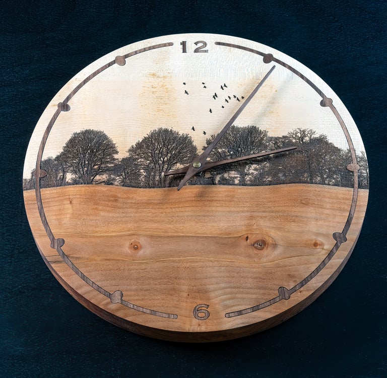 Round wooden wall clock featuring an engraved nature landscape with trees and birds.
