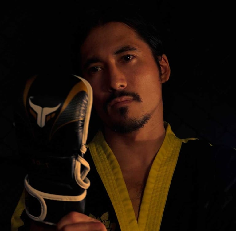 a man in a marcial arts uniform holding a pair of gloves