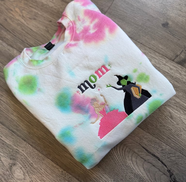 a white, pink and green tie dyed sweatshirt with the word "mom" embroidered on it