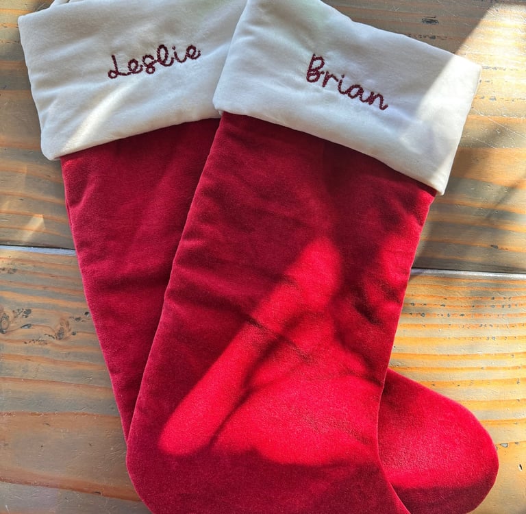two red stockings with names embroidered on them