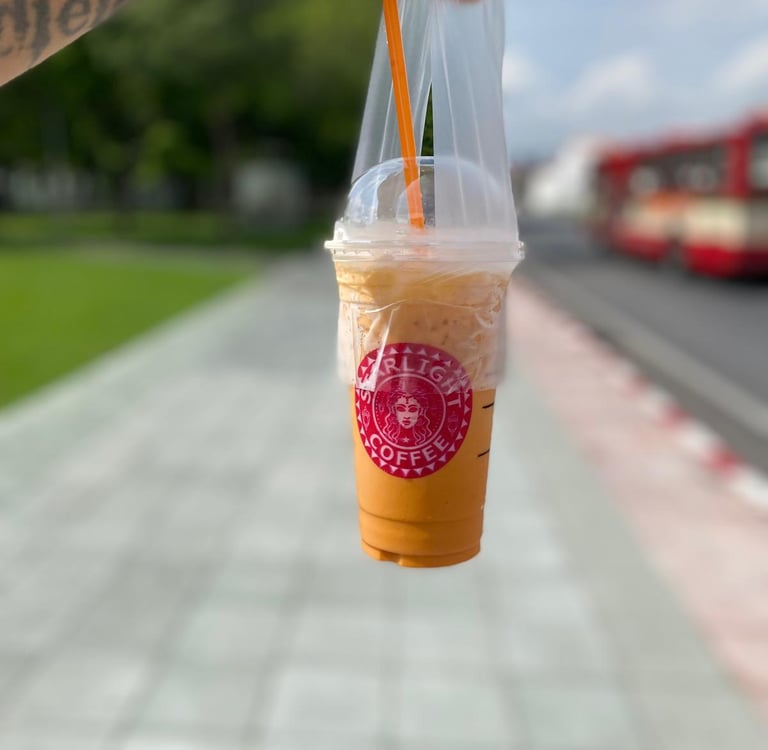 a person holding a cup of coffee in a plastic cup
