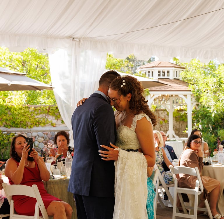 a bride and groom kissing in a tent