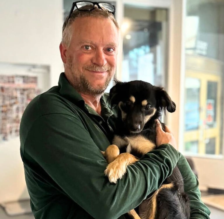 Kevin Enderle is holding a puppy