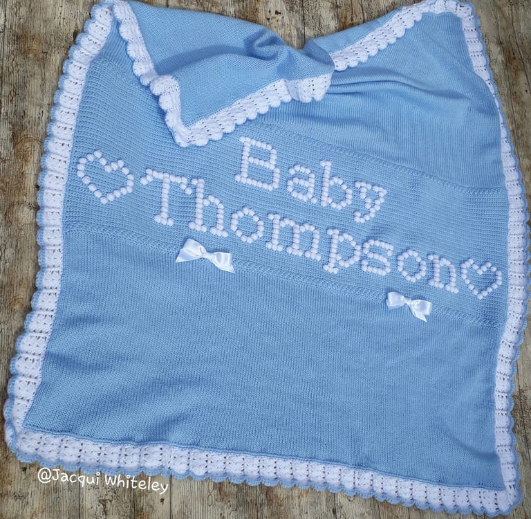 Custom made knitted and crochet baby blanket with raised lettering "Baby Thompson" and hearts.