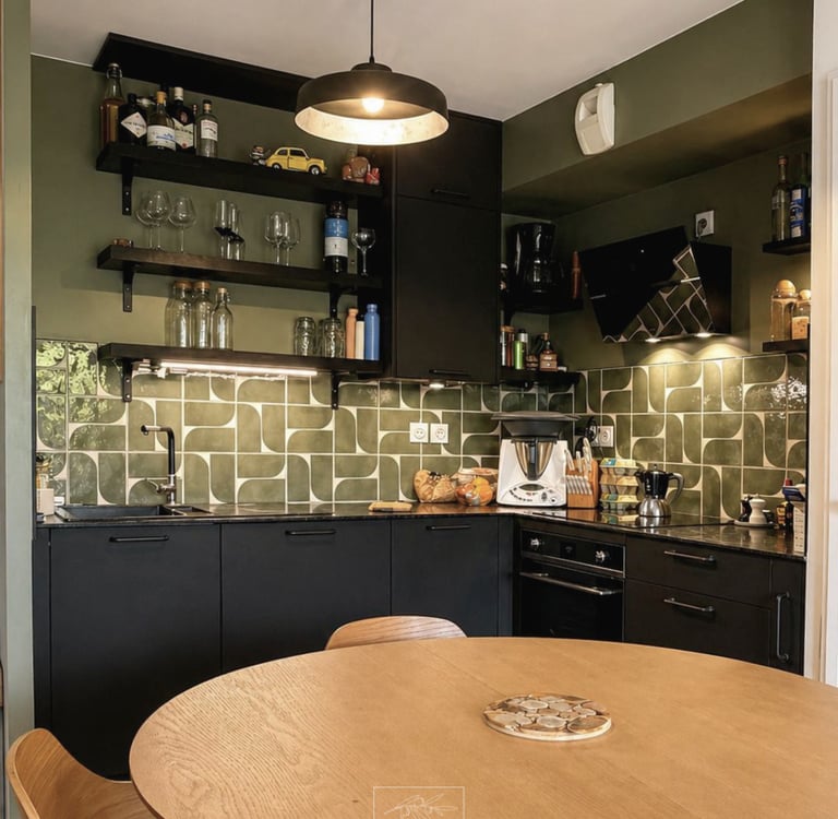 Rénovation cuisine à La Ciotat : meubles mats noirs, crédence graphique verte et table ronde en bois