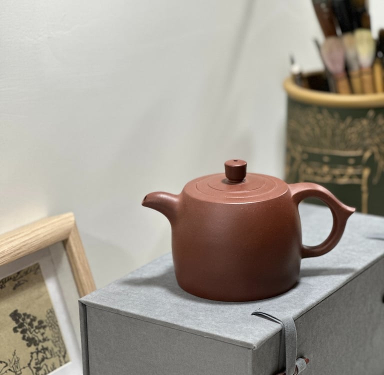 A brown Yixing teapot placed on a gray gift box