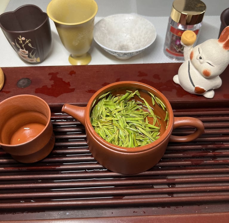 Tea set placed on a wooden tea tray, with green tea inside the teapot