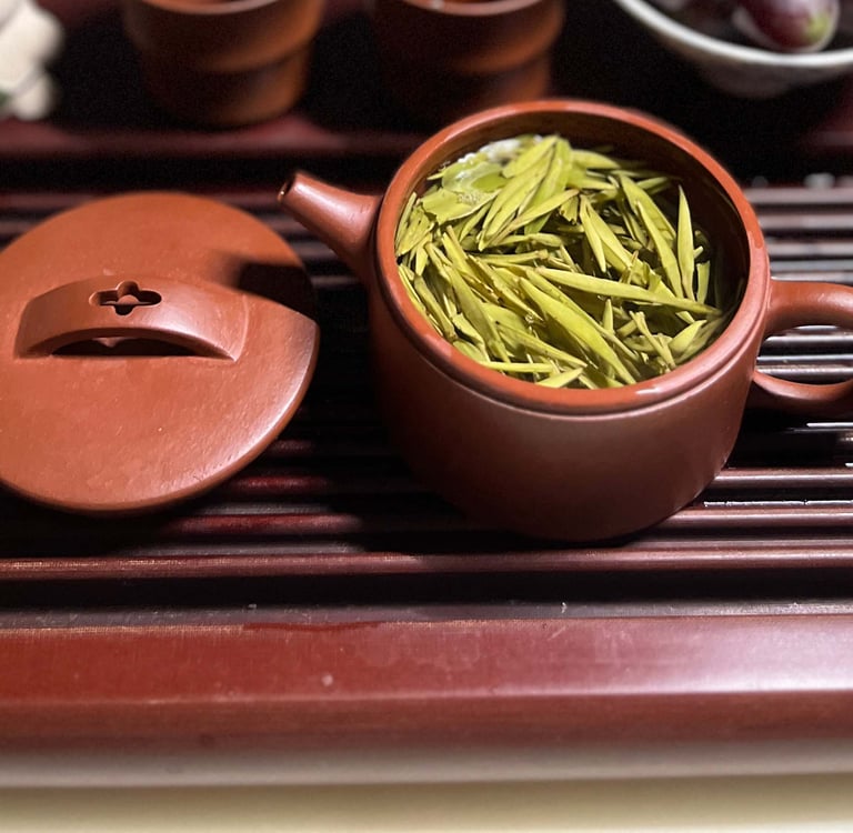 Tea set placed on a wooden tea tray, with green tea inside the teapot