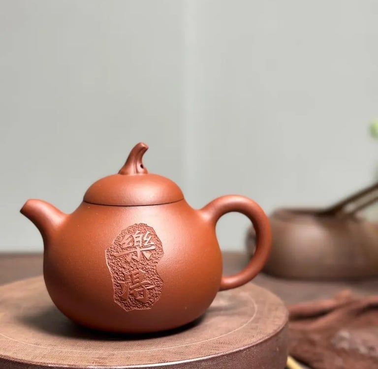 A teapot with engraved text placed on a wooden tabletop