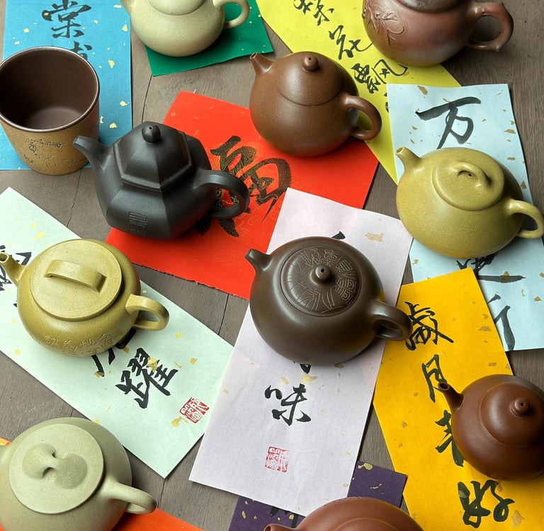 Several teapots arranged on various colored papers, each inscribed with different text