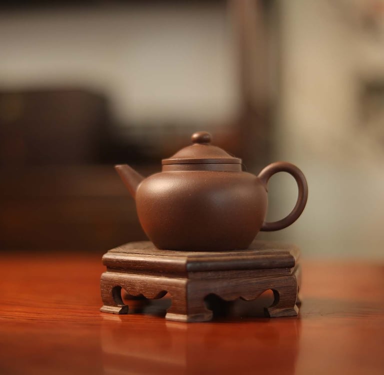 Dark brown teapot placed on a wooden stand