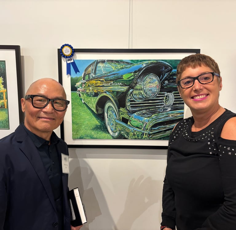 Photo of Sue and Peter Cheung (Judge) displaying 2nd place win painting