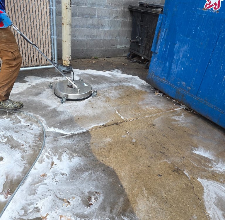 Pressure washing of a dirty dumpster enclosure