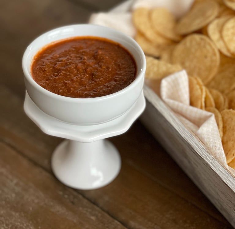 "Do the Dance" Hot salsa in a bowl beside a container with tortilla chips
