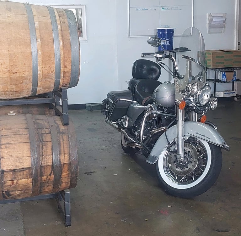 a motorcycle parked in a brewery with a barrel of beer