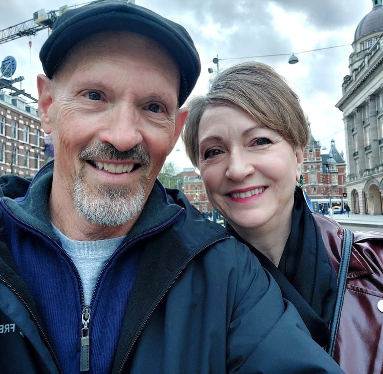 man and woman in front of buildings in amsterdam
