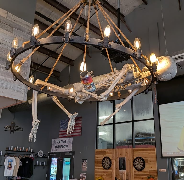skeleton hanging from a wheel-shaped chandelier