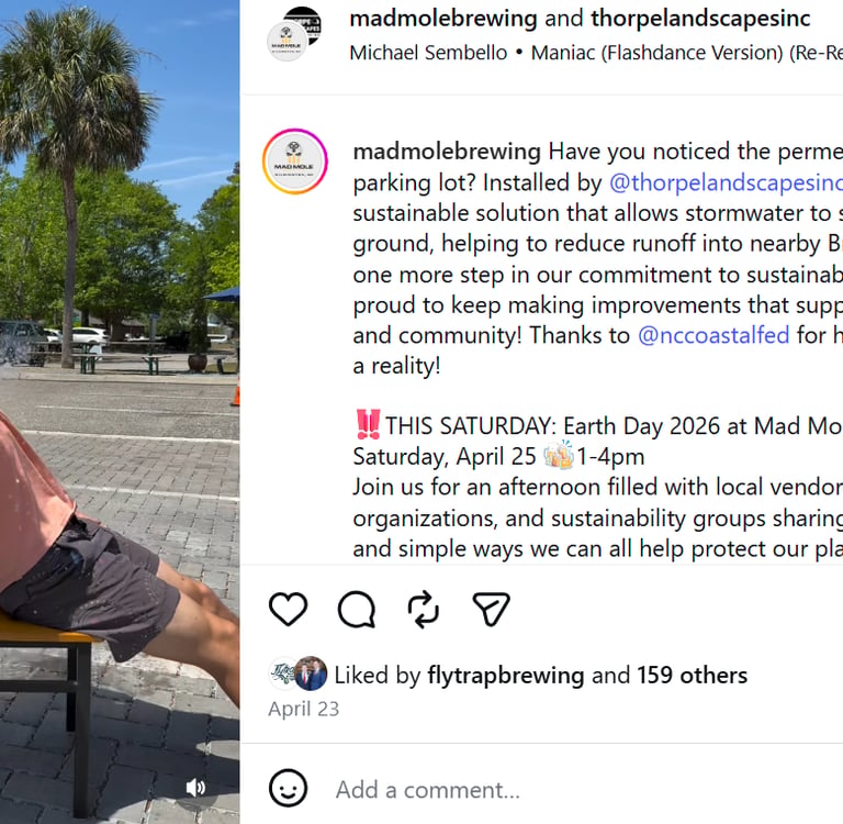 A person leaning back as water splashes them on permeable pavers at Mad Mole Brewing for Earth Day.