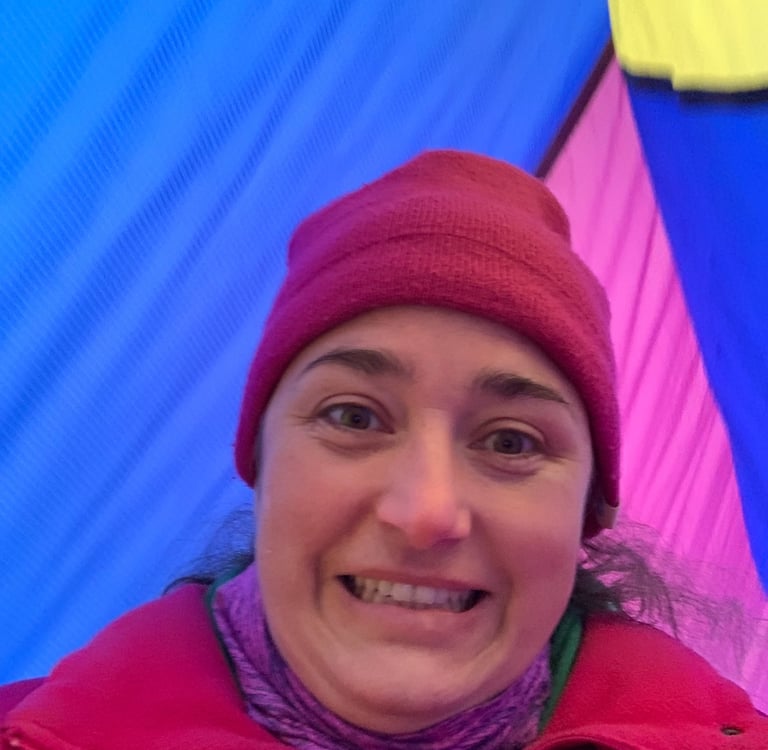Kayla Brooks standing between hot air balloons and looking excited