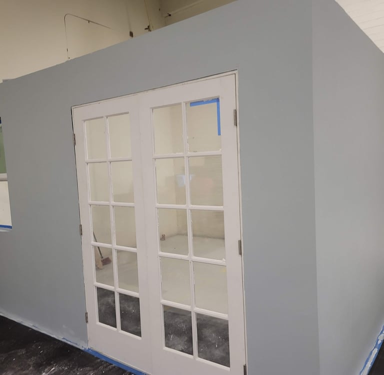 a room with a large white door and a blue wall