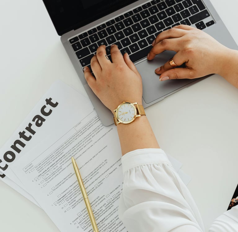 a woman sitting at a desk with a laptop and a watch