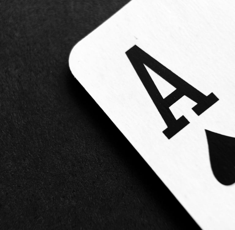 The corner of a playing card, the ace of spades, against a black fabric background.