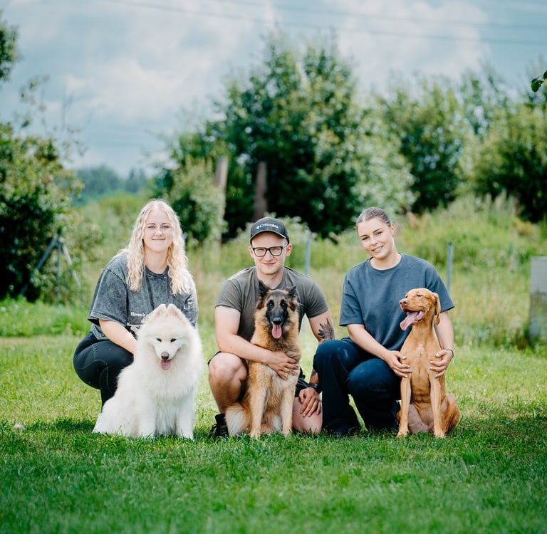 treneris su asistentėmis ir savo šunimis