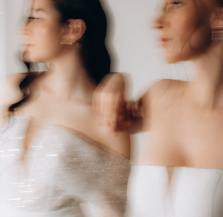 two women in white dresses standing next to each other