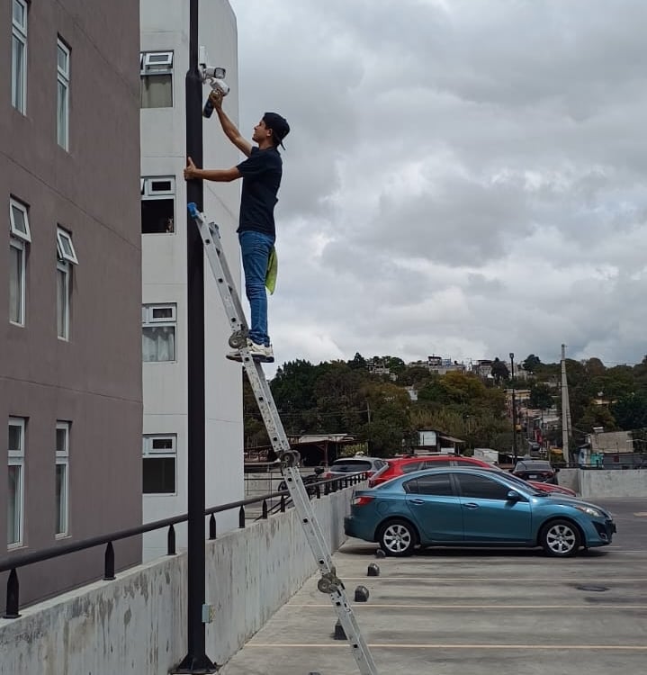 técnico realizando mantenimiento a cámaras de seguridad de un condominio