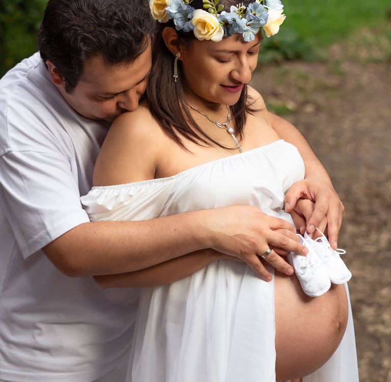 Foto profesional de maternidad embarazo en Quito Ecuador vientre descubierto con zapatos de bebé pareja de esposos