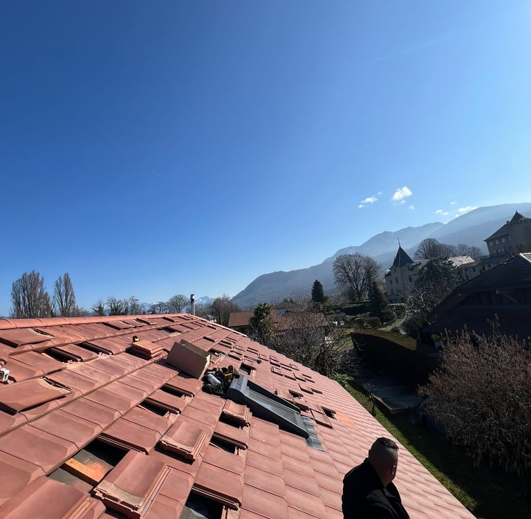 préparation de la toiture pentue autour d'un velux avant installation photovoltaïque de 9 kWc face au lac Léman