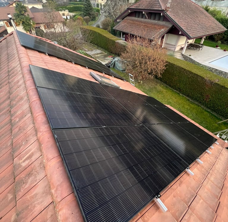 panneaux photovoltaïques installés sur toiture pentue avec vue sur les montagnes près du lac Léman