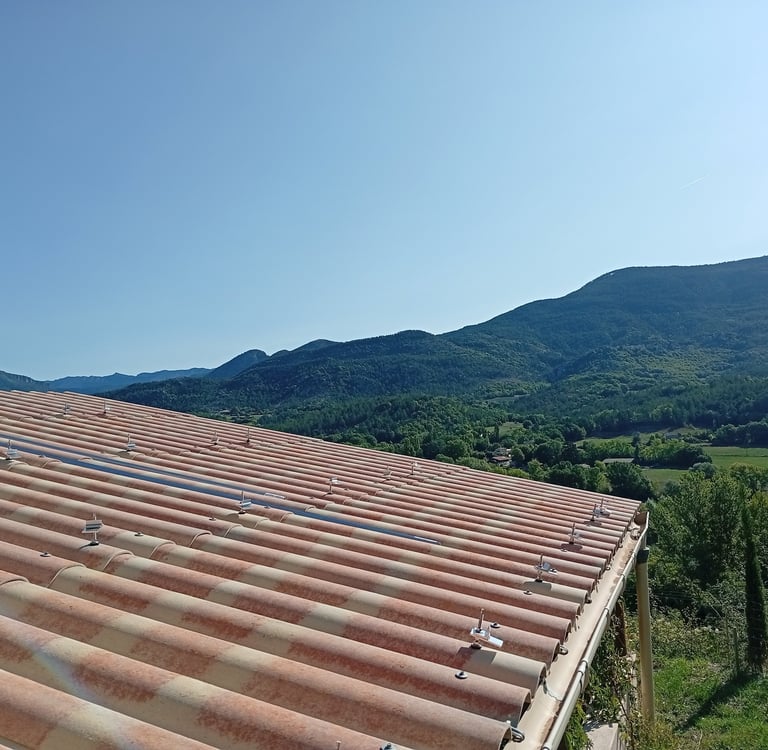 Fixations par tirfons installées sur toiture en plaques PST du carport à Mézel, préparation des rails pour panneaux solaires