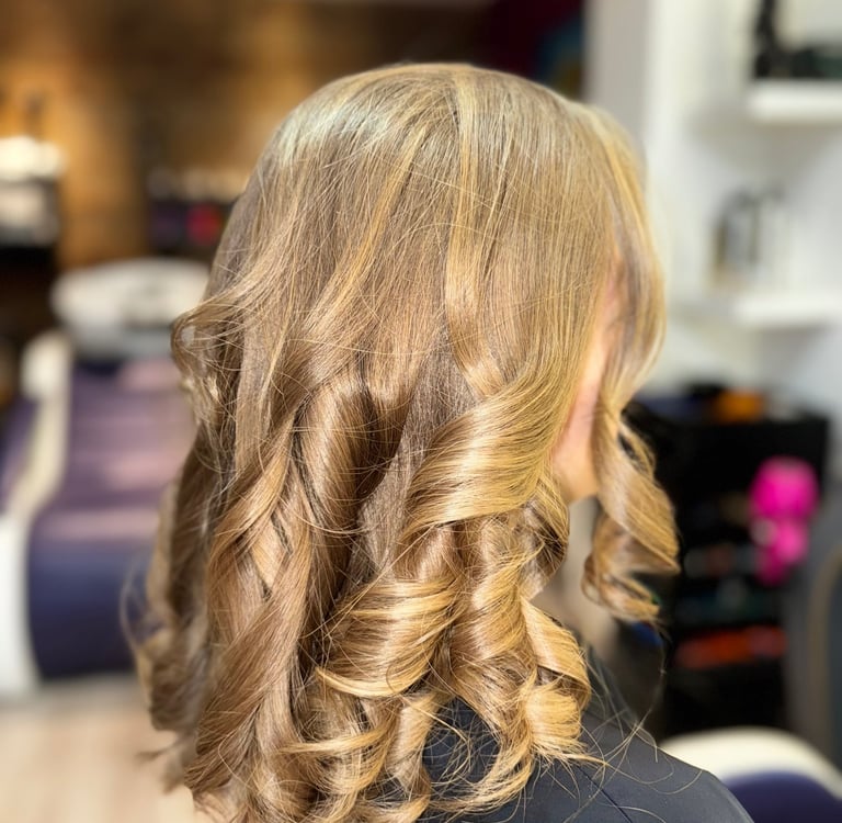 Une femme aux cheveux blonds portant un haut noir.