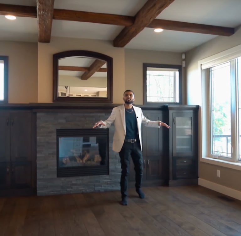 a man standing in a room with a fireplace
