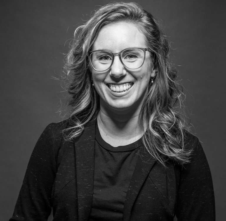 Miriam, une artiste maquilleuse qui sourit en noir et blanc