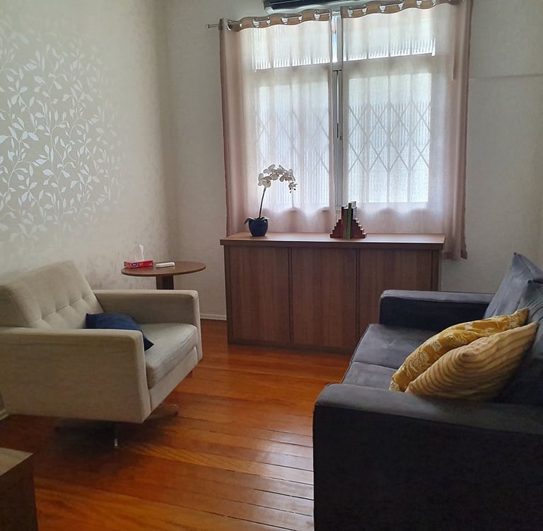 consultório de psicologia com sofá e janela