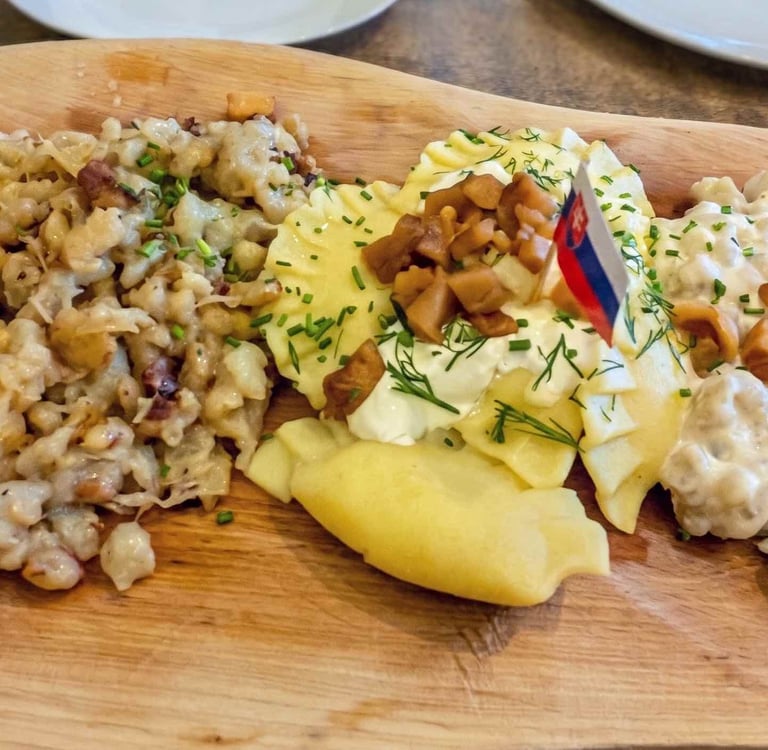 Plato combinado de comida tradicional eslovaca: bryndzové halušky y pírohy servidos en madera