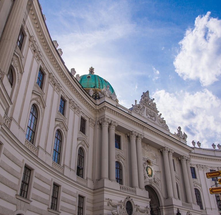 Fachada principal del Palacio de Hofburg en Viena con sus cúpulas verdes y arquitectura imperial.