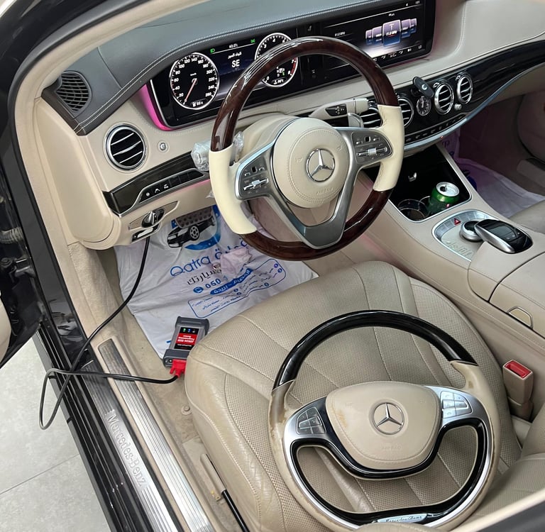 Luxury Mercedes-Benz interior featuring a wood-trimmed steering wheel and digital dashboard display.