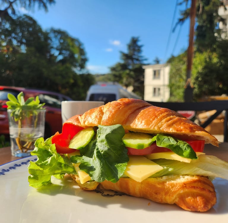 içinde salatalık, domates, yeşillik ve avokado buluanan kruvasan