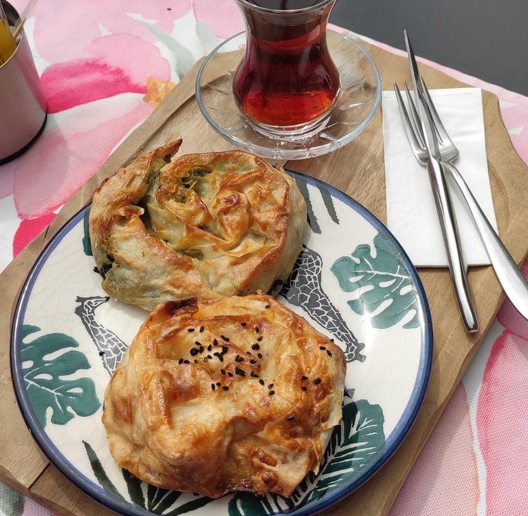cay ve tabakta börek olan masa