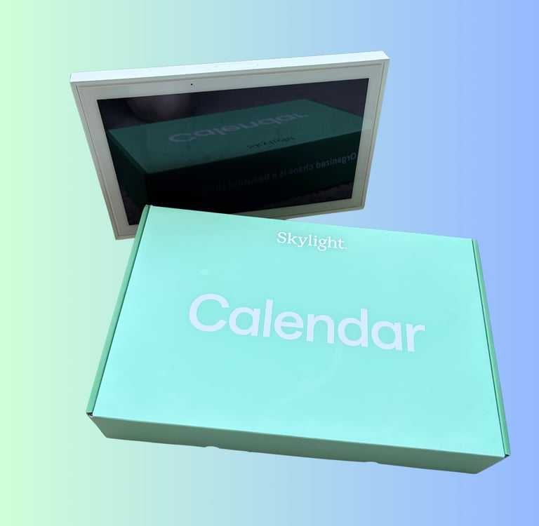 Skylight digital calendar smart display with its green retail packaging on a gradient background.