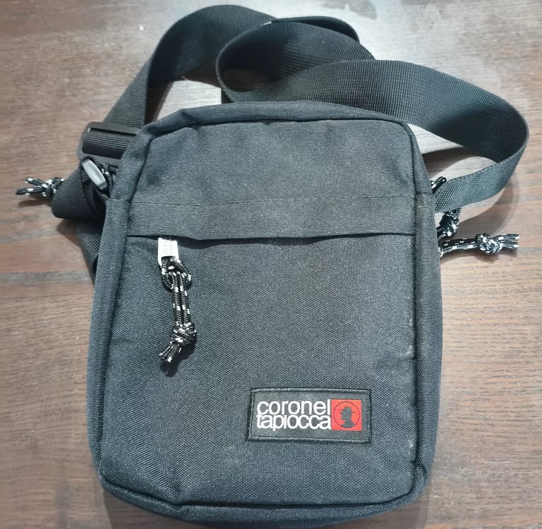Análise do bolso frontal e tecido resistente de mala tiracolo preta da marca Coronel Tapiocca.