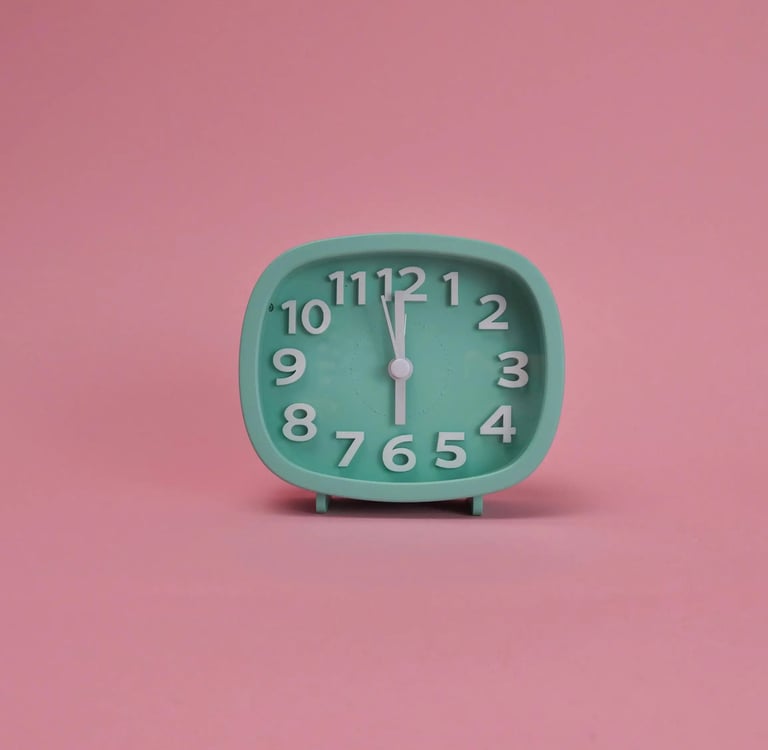 A teal analog alarm clock showing 6:00 on a solid pink background.