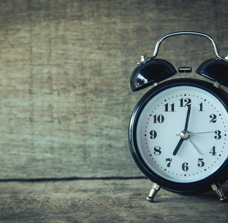 Alarm clock in front of wooden wall